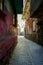 Vertical shot of a narrow street between aged buildings