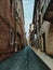 Vertical shot of a narrow street with brick buildings with windows