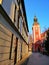 Vertical shot of narrow street leading to a red tower in Jelenia GÃ³ra, Poland