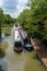 Vertical shot of a narrowboat passing moored narrowboats on a canal in Crick, UK
