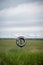 Vertical shot of a natural field and a car wheel sign has a writing no hunting and no trespassing