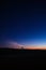 Vertical shot of the night over the silhouette of the land and a lighthouse in the background