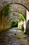 Vertical shot of old brick arches leaning over a river stream in a forest