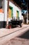 Vertical shot of an old tricycle parked on the pavement by the building