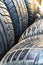 Vertical shot of old used worn car wheel tyres pile stacked in rows