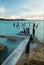 Vertical shot of an old weathered pier by the sea at sunset