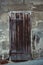 Vertical shot of an old weathered traditional wooden door with rusty metallic handle on the street