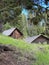 Vertical shot of old wooden huts in the woods