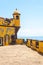 Vertical shot of the old yellow watchtower at the Forte de Sao Tiago beach of Funchal, Madeira