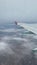 Vertical shot of one side of an airplane's wing on a foggy day from inside of the plane