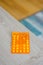 Vertical shot of an orange pile of medical tablets on a wooden surface