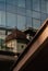 Vertical shot of outdoor buildings reflected on glass building