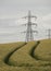 Vertical shot of overhead electric power transmission towers standing in a field