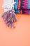 Vertical shot of a pair of colorful mittens on an orange surface