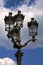 Vertical shot of parisian street lamp on blue cloudy sky background