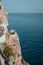 Vertical shot of a party on the side of a cliff over the water in Mallorca, Spain