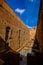 Vertical shot of a pathway with a ceramic floor in the middle of a brown walls