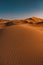 Vertical shot of a peaceful desert under the clear blue sky captured in Morocco