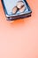 Vertical shot of pebbles on a rectangular box filled with small blue rocks on pink background