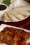 Vertical shot of Peking lacquered duck, crepes, and sauce on a wooden surface