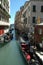 Vertical shot of people riding gondolas on the body of water near buildings in Venice, Italy