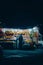 Vertical shot of a person buying fruits in a market at night