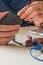 Vertical shot of a person connecting a hard drive to a laptop on the table