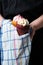 Vertical shot of a person holding two cupcakes on a kitchen towel