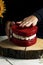 Vertical shot of a person preparing a fancy red velvet cake in a heart shape