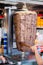 Vertical shot of a person preparing meat for Doner Kebab under the lights