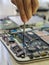 Vertical shot of a person repairing a tablet with a screwdriver