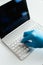 Vertical shot of a person sanitizing a laptop and keyboard