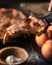 Vertical shot of a person taking a piece of a pie near a bowl of peaches