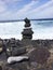 Vertical shot of a pile of a balanced stone pyramid with a wavy sea background