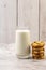 Vertical shot of a pile of chocolate chip cookie beside a glass of milk on a table