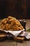 Vertical shot of a pile of fried chicken wings and some spices on a wooden table