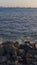 Vertical shot of a pile of rocks at a beach in Chimbote, Peru with the sea tides washing over them