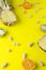 Vertical shot of pineapple,orange,kiwi fruit and peanuts in shell on yellow bright background