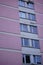 Vertical shot of a pink apartment with windows near to each other