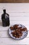 Vertical shot of a plate of dried palm fruits on a wooden table with a lantern on it