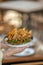 Vertical shot of a plate of tortilla chips with sauce in a woman's hands