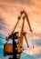 Vertical shot of a portal crane under a beautiful sunset skiy background