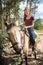 Vertical shot of a pretty young woman sitting on a horse and riding it