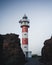 Vertical shot of the Punta Teno Lighthouse behind the rocks in Spain