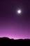 Vertical shot of a purple sky with a shining star and silhouettes of hills