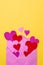 Vertical shot of purple Valentine envelope with colorful hearts on yellow background