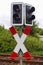 Vertical shot of railway light signs and an `X` symbol for stop beside a train railroad