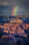 Vertical shot of a rainbow over a rock formation scenery