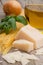 Vertical shot of raw spaghetti, parmesan, and basil on a wooden surface