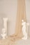 Vertical shot of the Renaissance epoch gypsum statues arranged with fabric on white background